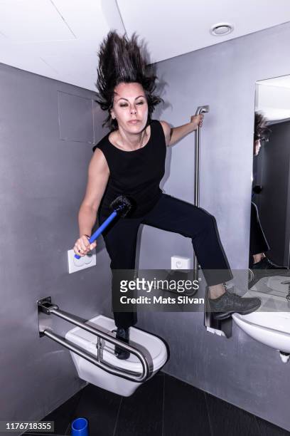 rock musician holding toilet brush and singing in bathroom - nightclub bathroom stock pictures, royalty-free photos & images