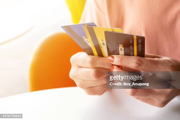 cropped shot view of female hands holding her credit cards. - credit card and stapel stockfoto's en -beelden