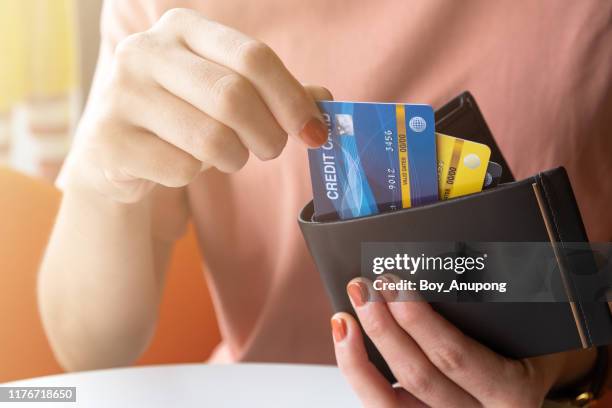 cropped shot view of female hands picking credit cards from her wallet. - borrowing stock pictures, royalty-free photos & images