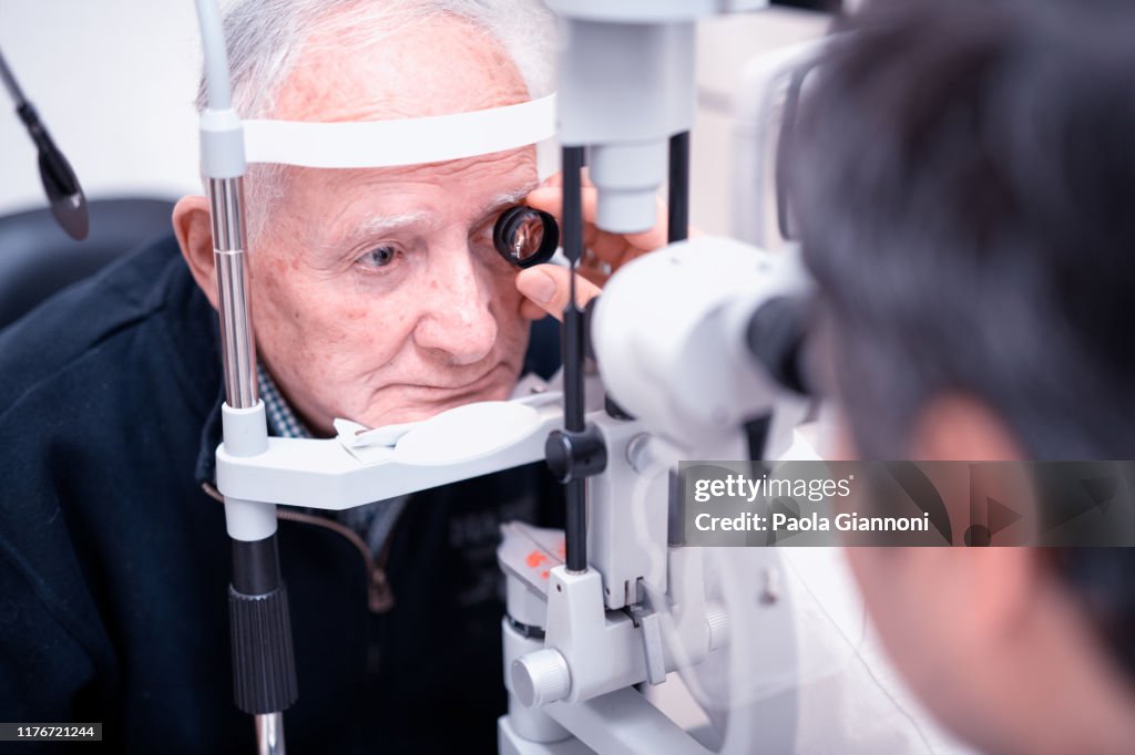Elderly man with retinal vein occlusion visiting by the ophthalmologist before laser treatment