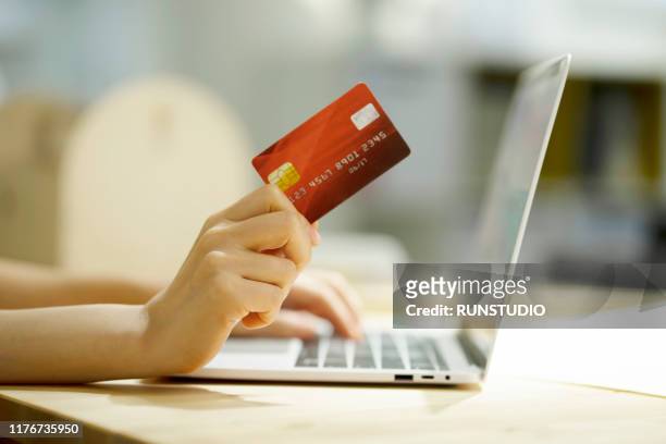 cropped hand of woman shopping online with credit card - ホームショッピング ストックフォトと画像