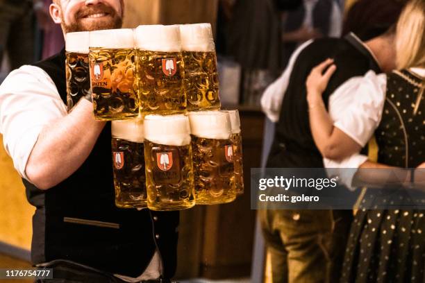 kellner mit viel bier im bierzelt beim oktoberfest - oktoberfest stock-fotos und bilder