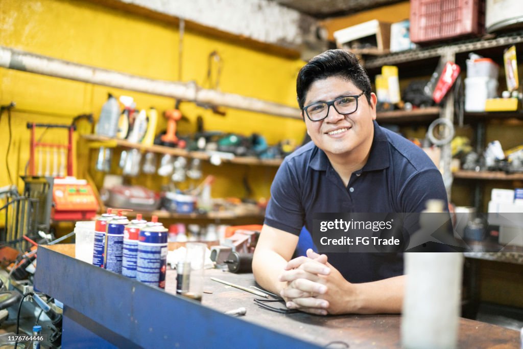 Retrato de um mecânico que trabalha em uma auto loja de reparo