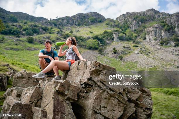 ett ungt par satt med en förfriskning paus på landsbygden - fickplunta bildbanksfoton och bilder
