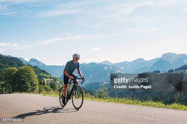 senior cyclist on the col de l'encrenaz - sports cyclist stock-fotos und bilder