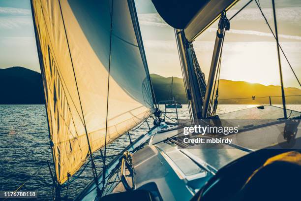 sailing with sailboat at sunset - sloop stock pictures, royalty-free photos & images
