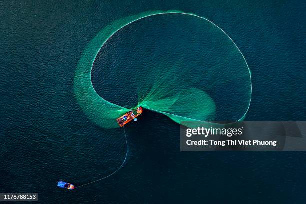 a fishing boat is opening a fish net to catch fishes on the sea of phu yen vietnam - fischnetz stock-fotos und bilder