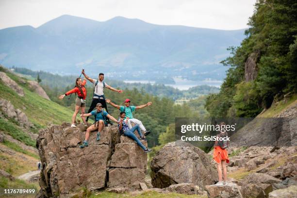 friends posing for the camera on top of a rock - field trip stock pictures, royalty-free photos & images