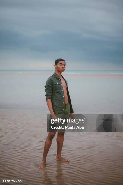 young man on beach - barefoot black men stock pictures, royalty-free photos & images