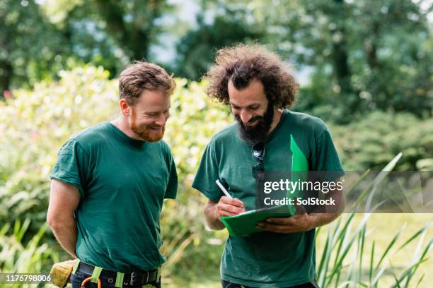 zwei landschaftsgärtner machen notizen auf derablage - landscaping garden stock-fotos und bilder