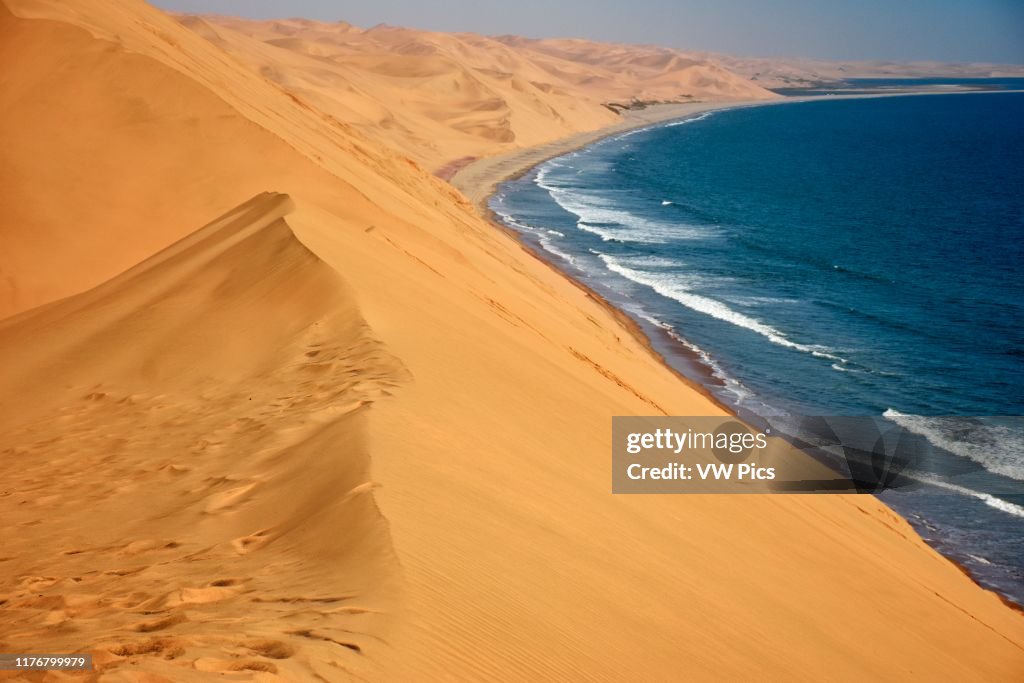 Sand dunes approaching the Atlantic Ocean close to Sandwich Harbor. Namib-Naukluft National Park. Walvis Bay. Namibia