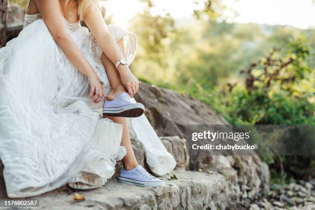 novia cansada cambiando de zapatos - zapato de tela fotografías e imágenes de stock