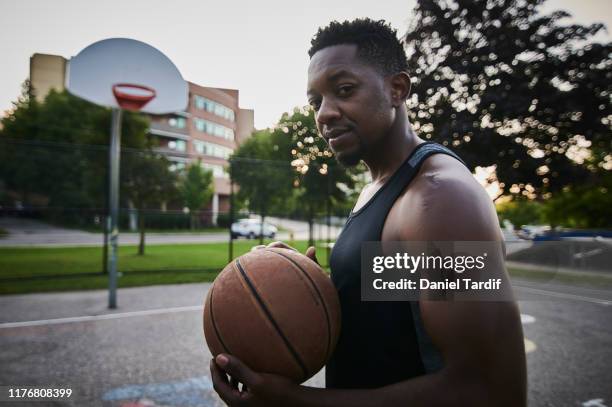 young athletic man on outdoor city basketball court. - toronto people stock pictures, royalty-free photos & images