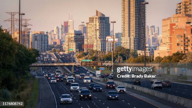 telephoto view toward downtown toronto with commuter traffic on highway - etobicoke ontario stock pictures, royalty-free photos & images