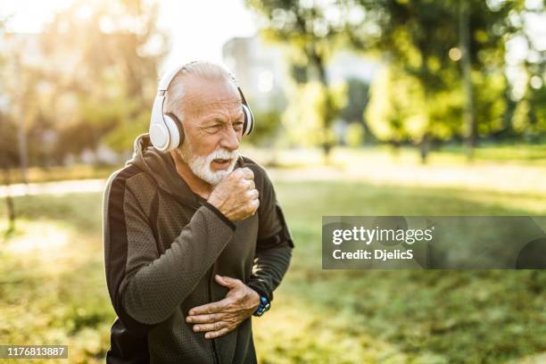 sporty senior man coughing. - old cough stock pictures, royalty-free photos & images