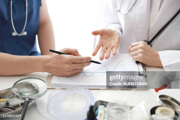 doctors discussing about medical chart - medical chart stock pictures, royalty-free photos & images