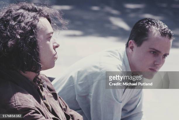 Curt Smith and Roland Orzabal of English pop duo Tears For Fears, seated on a bench together in London, April 1985.