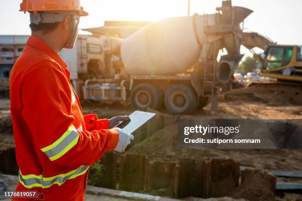 engineers are inspecting the pouring of the cement floor with tablets at an outdoor construction site. - trench safety stock pictures, royalty-free photos & images