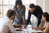 Focused multiracial corporate business team people brainstorm on paperwork
