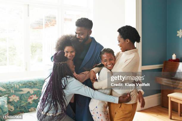 cheerful girls embracing man and woman at home - adolescent africain photos et images de collection