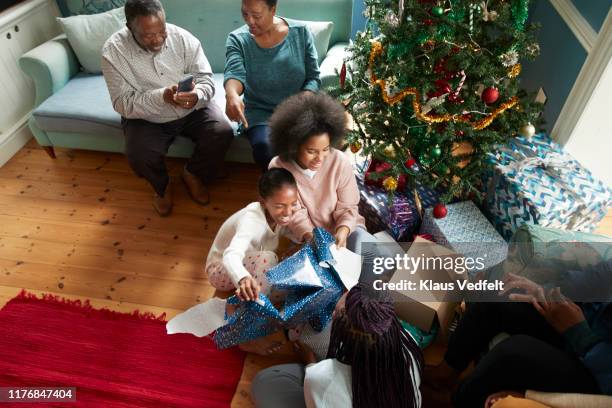 grandparents looking at girls opening gifts - open day 14 stock pictures, royalty-free photos & images