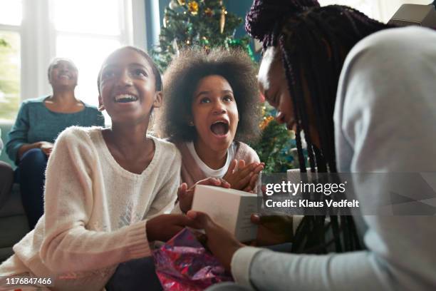 excited sisters looking at christmas present - open day 13 stock pictures, royalty-free photos & images