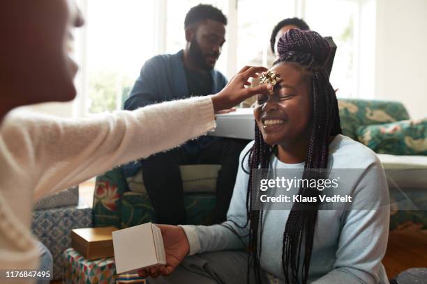 playful girl putting ribbon on sister forehead - open day 13 imagens e fotografias de stock