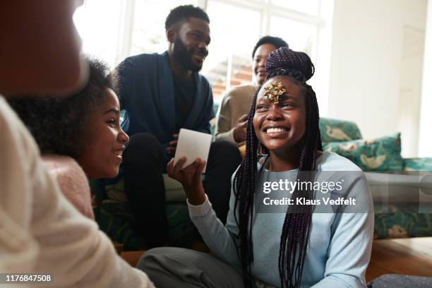 teenage girl showing christmas present to sisters - funny gifts photos et images de collection