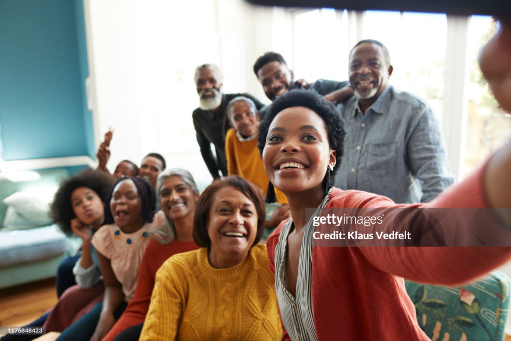 Young woman taking selfie with family and friends