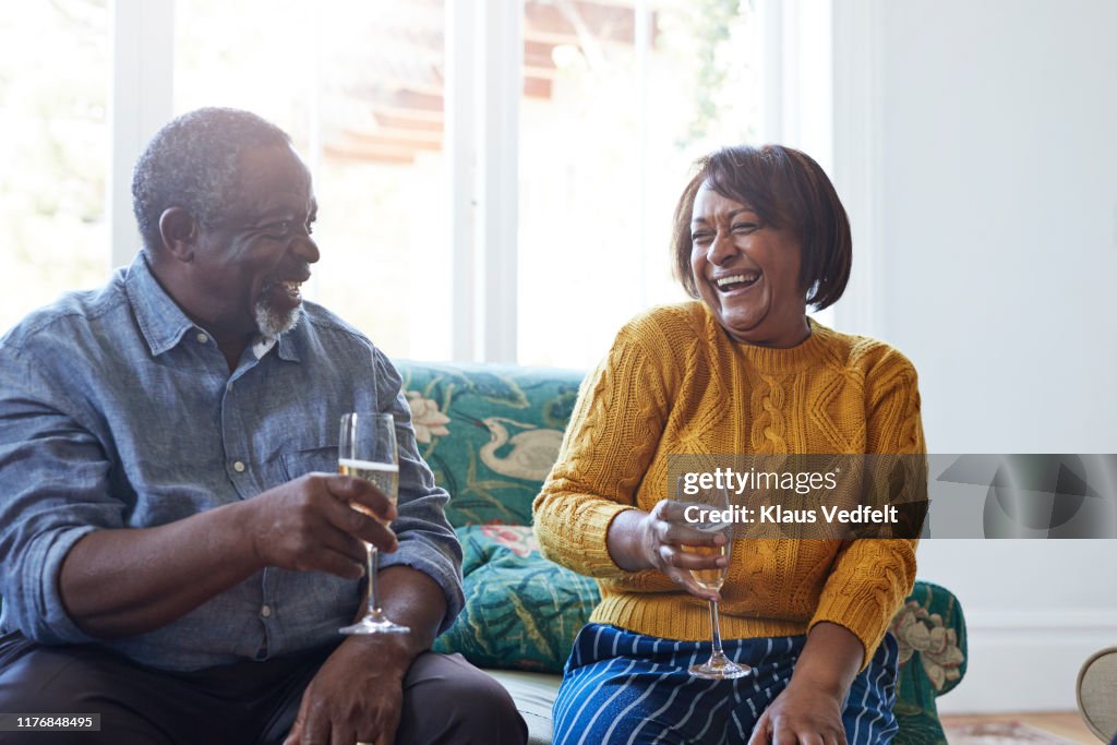 Cheerful friends while talking at home at party