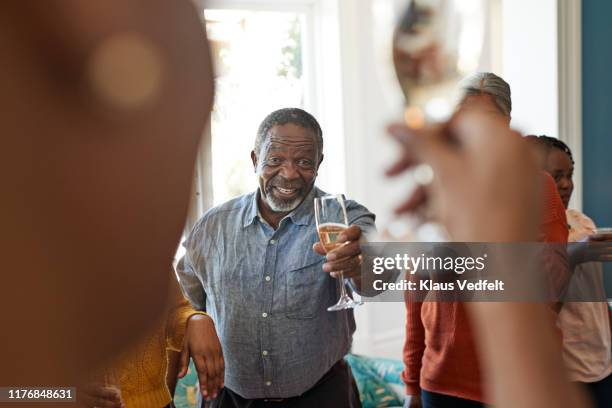 portrait of cheerful senior man showing champagne - seulement des hommes seniors photos et images de collection