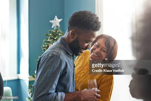 smiling friends talking in christmas party at home - mother son home stock pictures, royalty-free photos & images