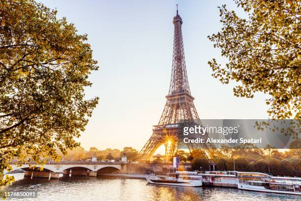 eiffel tower and seine river at sunrise, paris, france - paris france stock-fotos und bilder