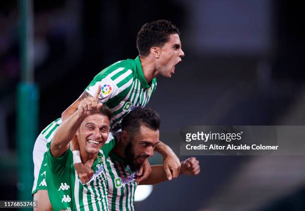 Borja Iglesias of Real Betis Balompie celebrates with his teammates Joaquin Sanchez and Marc Bartra of Real Betis Balompie after scoring his team's...