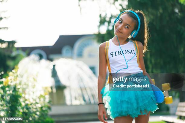 happy teenage girl with skateboard and headphones - tween girls hot imagens e fotografias de stock