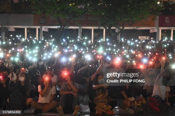 People light up their mobile phones during a prayer meeting and rally in support of pro-democracy protesters at Edinburgh Place in Hong Kong's...