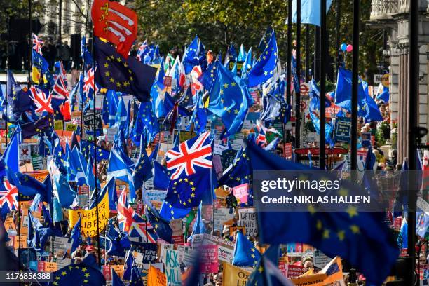 Demonstrators hold placards and EU and Union flags as they take part in a march by the People's Vote organisation in central London on October 19...