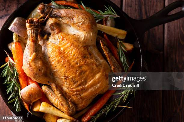 cast iron chicken - roast chicken table stock pictures, royalty-free photos & images