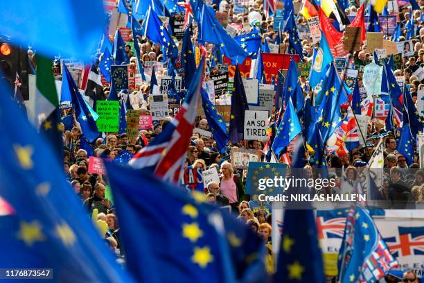 Demonstrators hold placards and EU flags as they take part in a march by the People's Vote organisation in central London on October 19 calling for a...