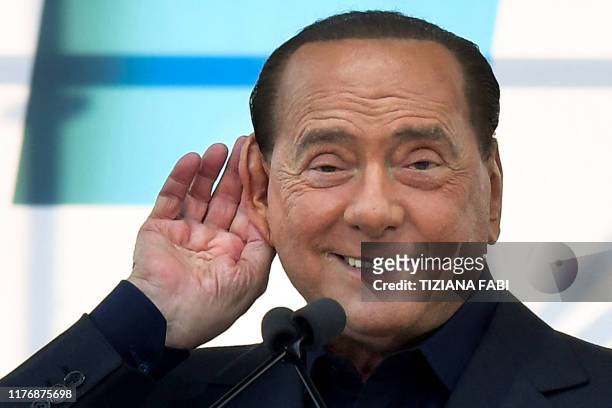 Leader of Italy's liberal-conservative party Forza Italia, Silvio Berlusconi gestures as he speaks during a rally of Italy's far-right League party,...