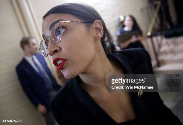 Rep. Alexandria Ocasio-Cortez answers questions from reporters while entering a House Democratic caucus meeting at the U.S. Capitol where formal...