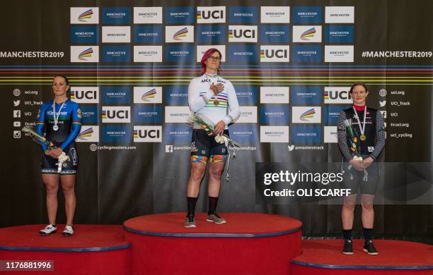 Canadian cyclist Rachel McKinnon celebrates her gold medal on the podium with bronze medalist Kirsten Herup Sovang of Denmark and silver medalist...