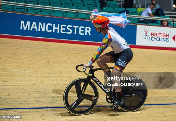 Canadian cyclist Rachel McKinnon carries a Transgender Pride flag as she celebrates winning the F35-39 Sprint Final during the 2019 UCI Track Cycling...