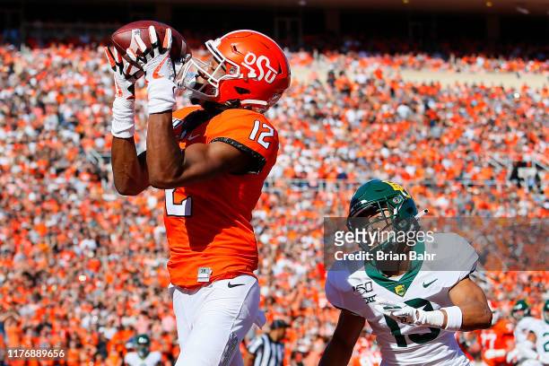 Wide receiver Jordan McCray of the Oklahoma State Cowboys wraps his hands around a touchdown pass over his shoulder against cornerback Raleigh Texada...
