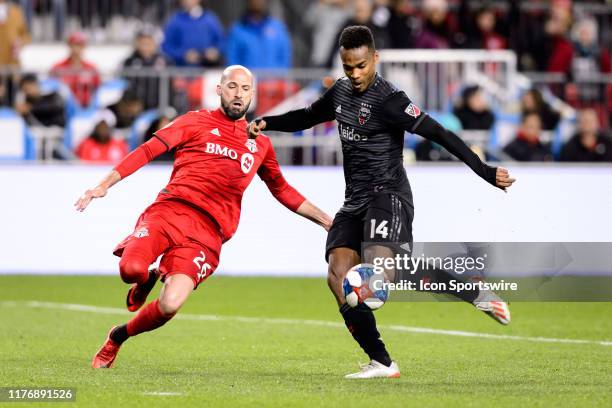 Laurent Ciman of Toronto FC attempts to block a shot by Ola Kamara of DC United during the second half of the MLS Cup Playoffs match between Toronto...