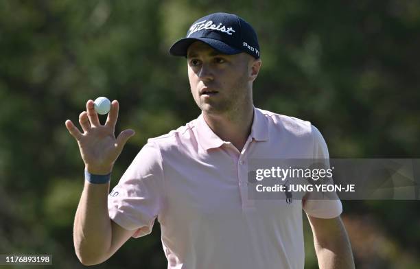 Justin Thomas of the US reacts after a birdie putt on the 3rd green during the final round of the CJ Cup golf tournament at Nine Bridges golf club in...