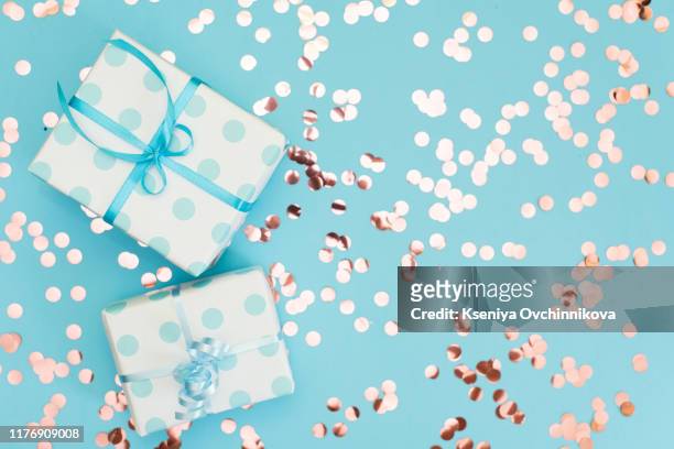 womans hands holding gift or present box decorated confetti on pink pastel table top view. flat lay composition for birthday or wedding. - birthday gift stock-fotos und bilder