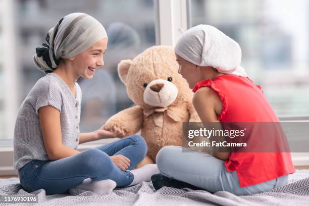 two girls with cancer playing together - leukemia stock pictures, royalty-free photos & images