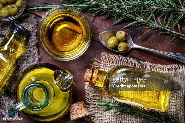 top uitzicht van olijven en olijfolie flessen op tafel in een rustieke keuken - bottles glass top stockfoto's en -beelden