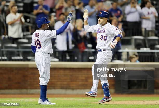 Michael Conforto of the New York Mets celebrates his two run home run with teammate Rajai Davis who also scored on the play in the ninth inning...